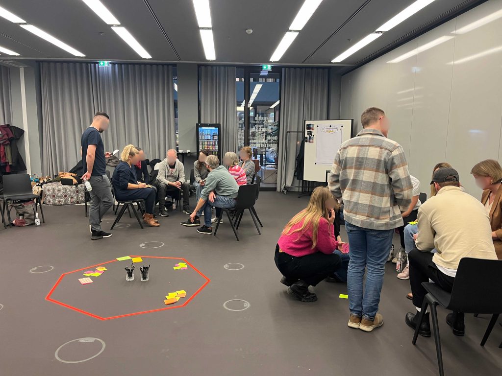 Großgruppen-Workshop in Köln: Sitzende Menschen in einem Konferenzraum in Köln beim Teamcoaching