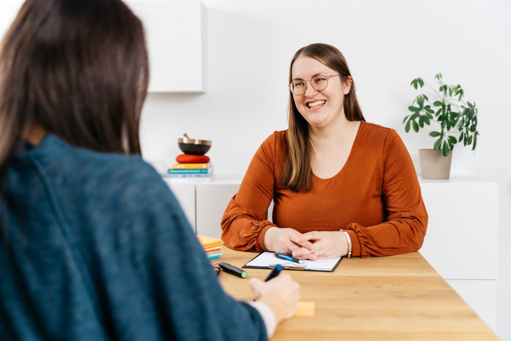 Lisa Schöffel Teamcoach und Teamentwicklerin beim Coaching sitzend