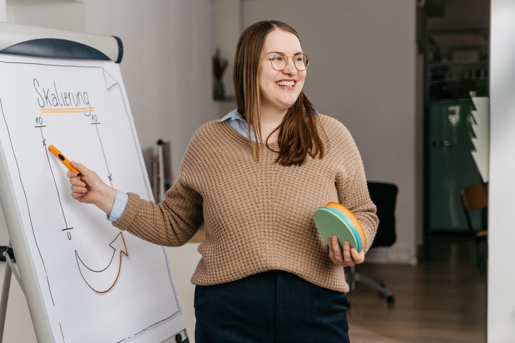 Lisa Schöffel bei der Teamentwicklung in Köln stehend mit Metaplan-Karten in der Hand